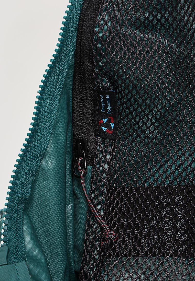 Türkiser Reißverschlussfach mit Netzfächern, strapazierfähigem recyceltem Polyamid und einer strukturierten Innenseite. Enthält einen Kordelzug und ein Markenlabel.