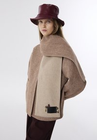 Geweven bruine wolblend buitenkleding met een groot beige paneel. Kenmerkt decoratieve accenten en een bordeauxlederen emmerhoed.