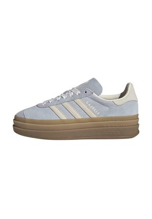 Light blue Adidas Gazelle sneaker with thick brown sole, white laces, and beige stripes on white background.