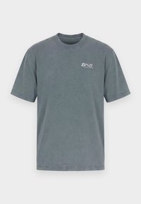 T-shirt grigia semplice a maniche corte con scollo rotondo e scritta bianca "DPSZE Denim Couture" sulla parte superiore sinistra del petto.