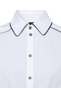 Weißes Hemd mit weitem Kragen, verziert mit schwarzem Besatz. Es hat eine Knopfleiste mit sechs metallischen Knöpfen und präsentiert eine glatte Textur.