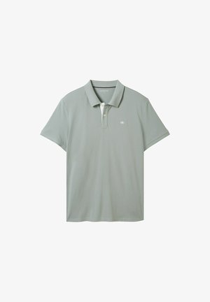 Polo vert clair à manches courtes, col côtelé, patte à deux boutons et petit logo sur la poitrine. Texture de tissu lisse.