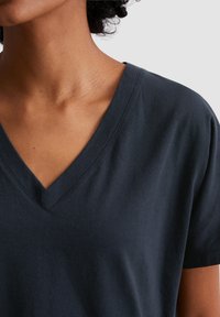 Dark navy V-neck t-shirt in soft cotton material, featuring short sleeves and a smooth texture with minimal seams and stitching details.