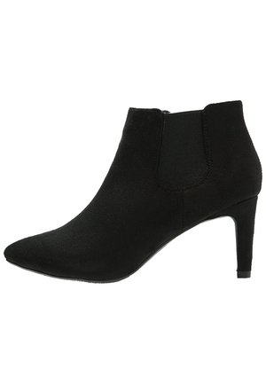 Sort ruskindslangsstøvle med spids tå, elastisk sidepanel og mellemhøj stiletthæl.
