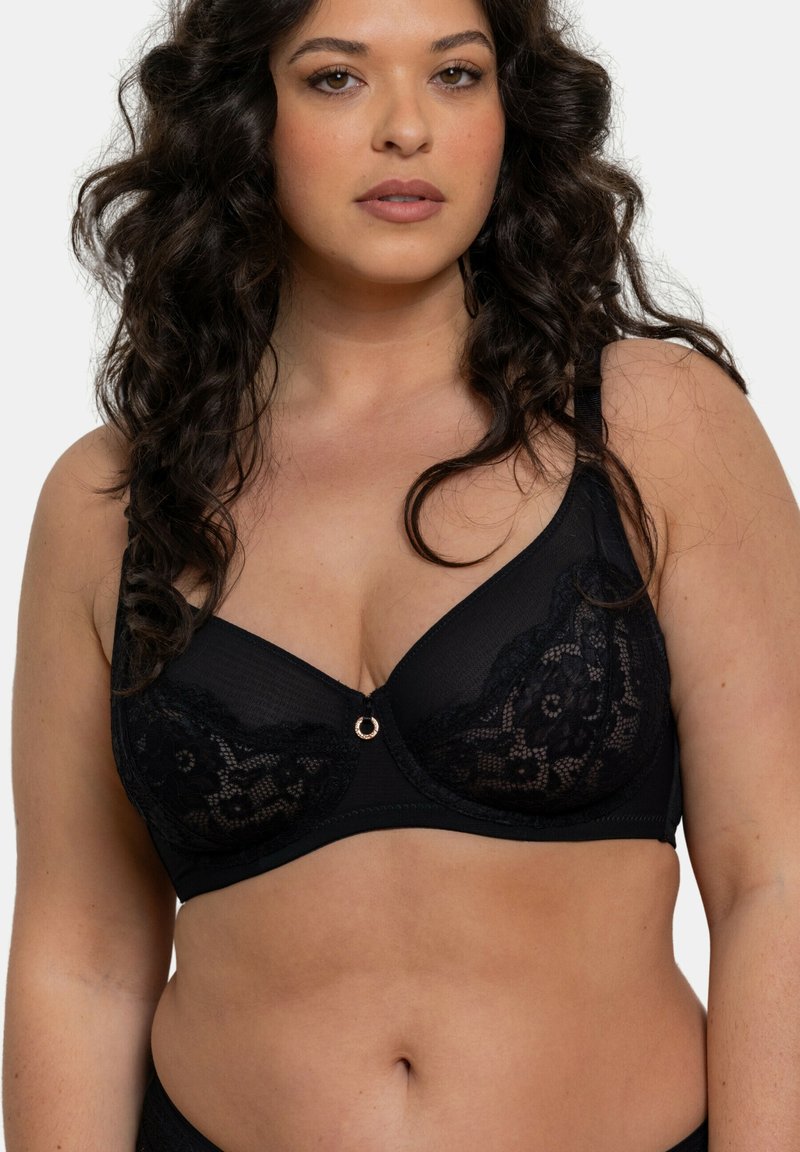 Soutien-gorge noir avec superposition en dentelle, soutien-gorge à armatures et bretelles réglables. Il présente un petit accent circulaire au centre avant.