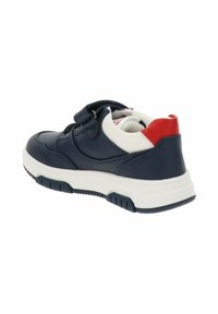 Zapatilla sintética de color azul marino con tira de velcro, acentos en blanco y rojo, punta redondeada, cuello acolchado y suela de goma texturizada.