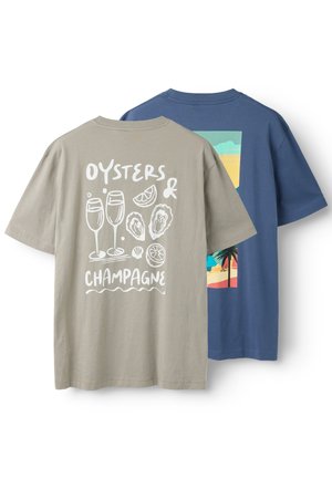 Dos camisetas de manga corta, una beige con ostras blancas, copas de champán, limón y el texto "Oysters & Champagne", y una azul con una escena de playa.