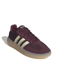 Maroonske atletske cipele sa nubuk gornjištem, tri krem i mornarske pruge, okrugli vrh, dizajn na vezivanje i prozirna gumena potplat.