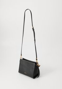 Schwarze Leder-Handtasche mit strukturiertem Design, verstellbarem Tragegurt, goldenen Hardware-Akzenten und einem Reißverschlussverschluss an der Oberseite.