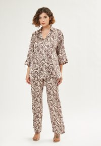 Bruine en beige gestreepte top met een kraag en losse mouwen, gecombineerd met bijpassende wijde broek. Gladde textuur, casual ontwerp.