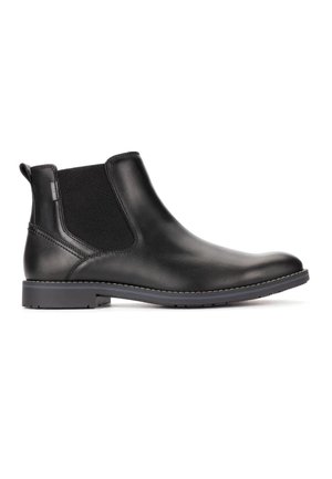 Stivale Chelsea in pelle nera con pannello laterale elastico, tirante sul tallone, suola cucita e tacco basso su sfondo bianco.