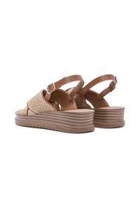Beige wedge sandals with woven texture, brown leather straps, and adjustable buckles, featuring a ridged outsole for traction.