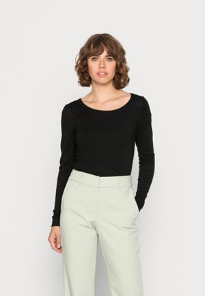 Musthave musta pikka varrukaga topp ümmarguse kaelusega, millele on sobitatud helegeensed kõrge vöökohaga püksid. Sile tekstuur, kitsas disain.