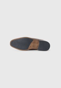 Suela de zapato de cuero marrón con una parte inferior de goma texturizada. Presenta una combinación de patrones lisos y acanalados para un mejor agarre y durabilidad.