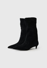 Stivaletti in suede nero con un design morbido, punta affusolata e tacco kitten basso. Tessuto liscio con dettagli di cucitura minimi.