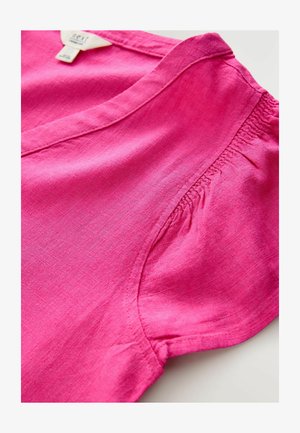 Fuchsia linen top with a V-neck and elasticized side seams, featuring a smooth texture and slight sheen. No visible patterns or accents.