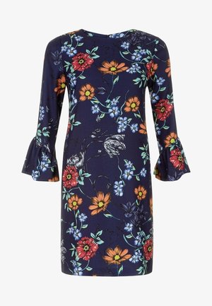 Kukallinen mekko tummansinisestä kankaasta, jossa on 3/4-pituiset kellotaskut. Mekossa on värikkäitä kukkia punaisena, oranssina ja sinisenä vihreillä yksityiskohdilla sekä pyöreä pääntie.