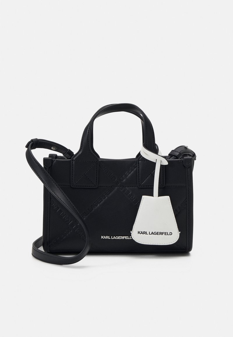 Sac à main noir Karl Lagerfeld avec anses supérieures, bandoulière amovible et étiquette blanche avec le nom de la marque sur l'avant.