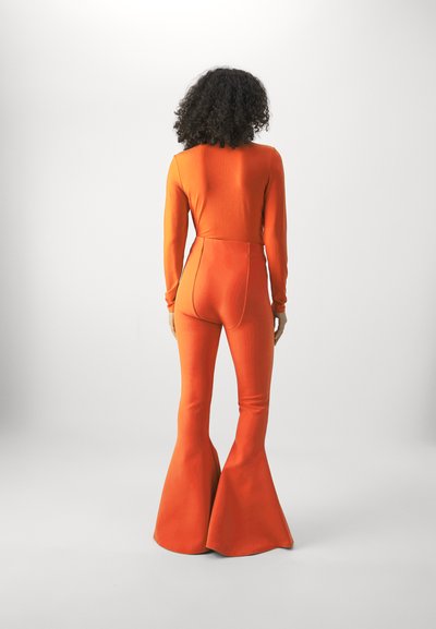 Orange ribbed bodysuit with long sleeves, paired with flared pants. Smooth texture, fitted silhouette, highlighting a vibrant color.