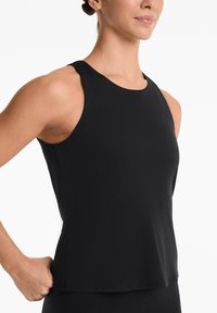 Black sleeveless athletic top made from smooth, stretchy fabric. Features a round neckline and a relaxed fit, suitable for active wear.