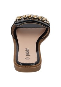 Zwarte platte slide sandaal met een glanzende lakafwerking, voorzien van een gouden kettingdetail over de bovenkant en een beige zool.