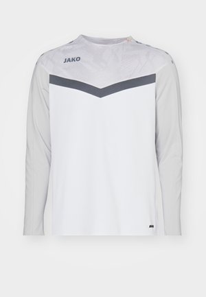 T-shirt de sport à manches longues en blanc et gris, présentant un panneau supérieur texturé, un détail en chevron gris foncé et un logo de la marque sur la poitrine.