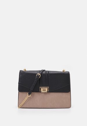 Czarna i beżowa teksturowana prostokątna torebka z złotym zapięciem, regulowanym paskiem i dekoracyjnym złotym łańcuszkiem na białym tle.