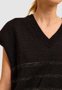 Schwarzes Stricktop mit V-Ausschnitt und breitem Schulterdesign. Es hat horizontale Streifen mit metallisch goldenem Akzent.