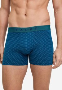 Blaue Boxer-Shorts mit einem grünen Bund, die ein sich wiederholendes vertikales Muster aus hellblauen Linien aufweisen. Hergestellt aus einem weichen, dehnbaren Stoff.