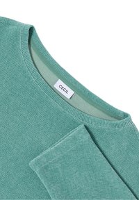 Mintgrön stickad tröja med strukturerad tyg, bred rundad halsringning och en sydd etikett med texten "CECIL." Inkluderar ribbade ärmslut för en nära passform.