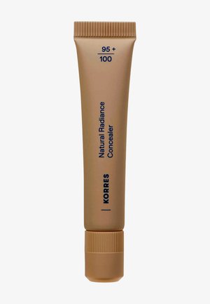 Korres Natural Radiance Concealer in shade 95+100, beige tube with screw cap, vertical dark blue text on light brown background.