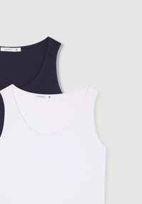 Due canottiere senza maniche: una in blu scuro, l'altra in rosa chiaro. Morbido cotone misto, collo rotondo e etichetta visibile sulla canottiera blu.