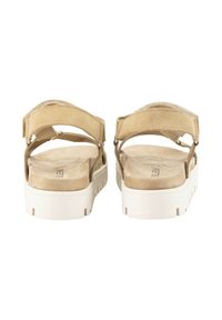 Sandalias de ante beige con correas ajustables y una plantilla texturizada. Suela de plataforma blanca con surcos para ofrecer agarre y estabilidad.