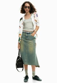 Valge särk lillemustriga, seljas halla tanktopi peal, kombineeritud tuhmunud sinise denimse seelikuga ja tumeroheliste tossudega. Must käsikott naeltega.