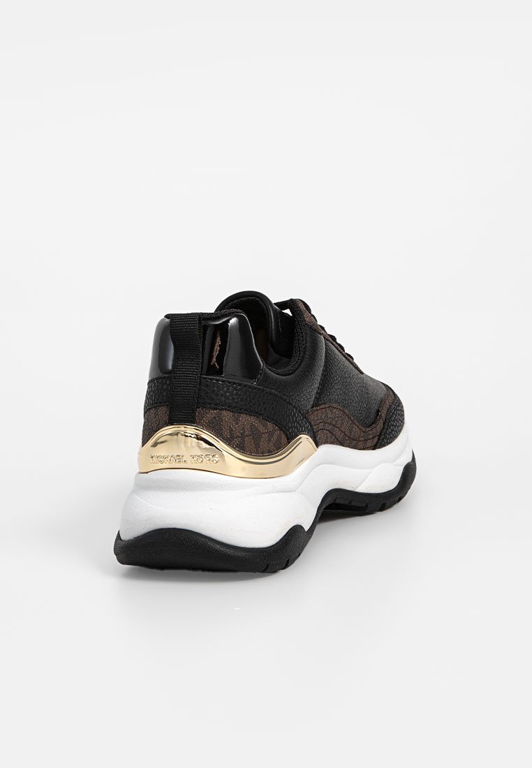 Zwarte sneaker met een textuur bovenwerk met gouden accenten, een gewatteerde kraag en een witte zool met een zwarte rubberen buitenzool.