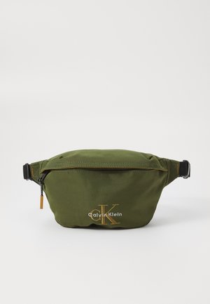 Riñonera verde de nailon con cierre de cremallera, correa ajustable y logotipo dorado de Calvin Klein. Textura suave, diseño ligero.