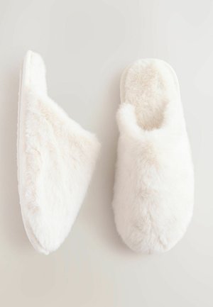 Pantofole bianche pelose con una texture morbida e soffice e un design della punta arrotondata. Stile slip-on con interni imbottiti e suola piatta.