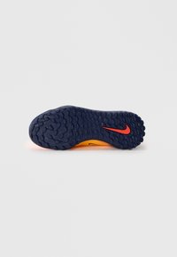 Podrážka Nike v modrej a oranžovej farbe s textúrovaným povrchom, na ktorej sa nachádza červené logo Nike. Sú viditeľné okrúhle vzory a drážky pre trakciu.