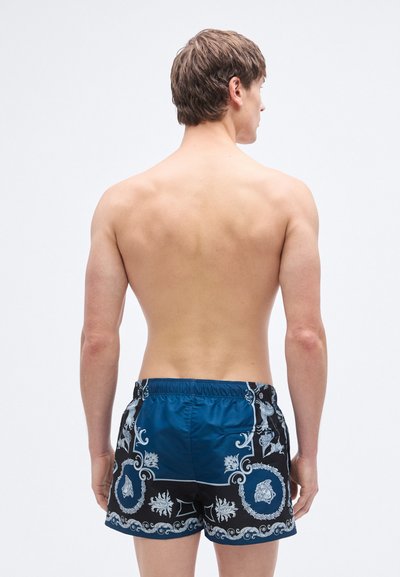 Μαύροι και μπλε ανδρικοί μαγιό με διακοσμητικό σχέδιο, ελαστική μέση και μία πίσω τσέπη. Λεία υφή.