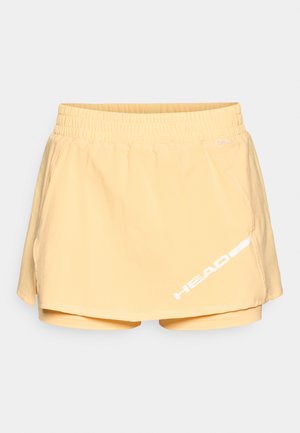 Gul sports skjørt med innebygde shorts, elastisk midje og hvitt logo-detalj på siden. Mykt stoff med en jevn tekstur.