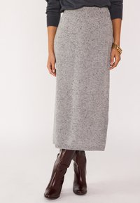 Jupe maxi en tricot gris avec une finition texturée, dotée d'une taille côtelée et de touches contrastantes, associée à des bottes bordeaux montantes.
