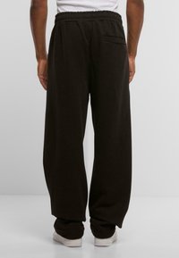 Sorte sweatpants med afslappet pasform, fremstillet af blødt stof, med elastisk talje og en baglomme.