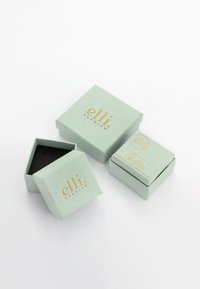 Cajas de joyería verde claro con texto dorado, una abierta para revelar un interior negro. Dos cajas cuadradas de diferentes tamaños, con un diseño simple.