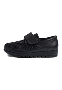 Chaussures en cuir noir avec un dessus tissé texturé, une sangle Velcro et une semelle en caoutchouc robuste présentant un motif de semelle pour l'adhérence.