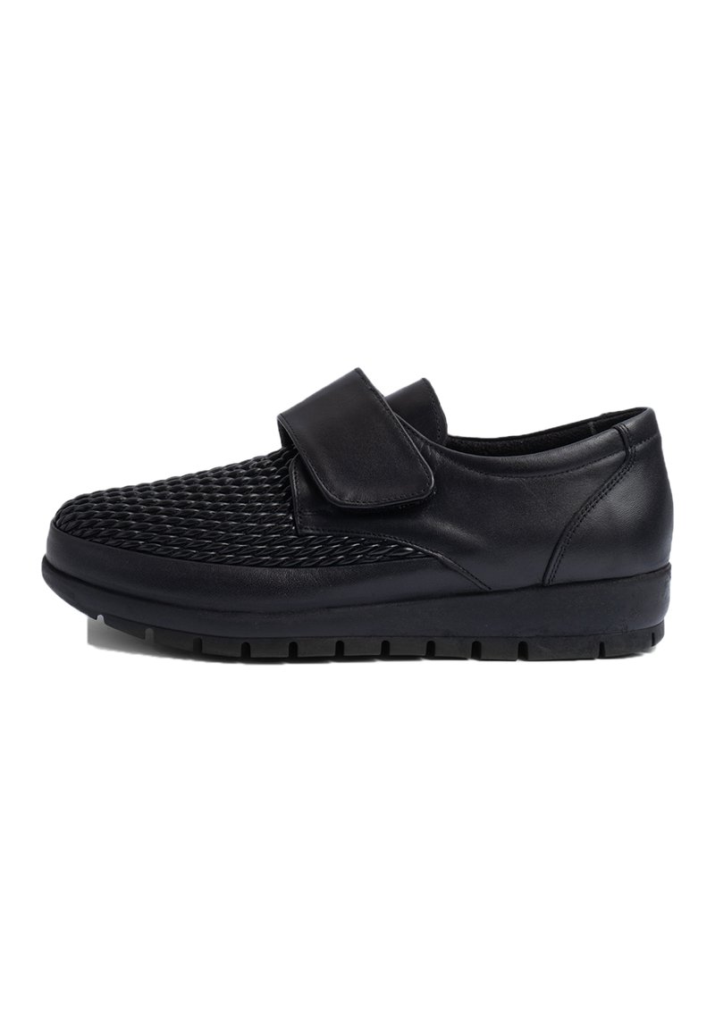 Chaussures en cuir noir avec un dessus tissé texturé, une sangle Velcro et une semelle en caoutchouc robuste présentant un motif de semelle pour l'adhérence.