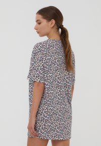 Abito t-shirt con stampa leopardo in tessuto morbido. Maniche corte, vestibilità comoda, con accenti viola e verde teal su sfondo grigio chiaro.