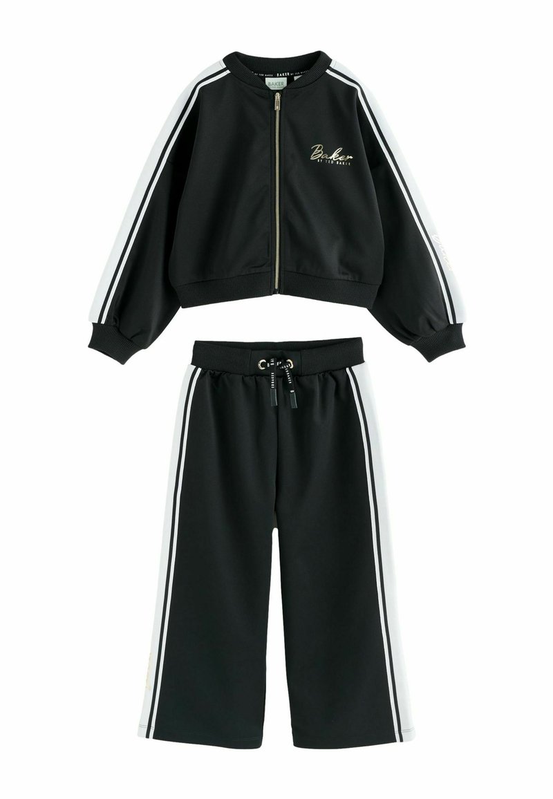 Čierny tréningový oblek s bomber bundou na zips a širokými nohavicami. Obsahuje biele pruhy na rukávoch a nohách, vyrobené z hladkej tkaniny.