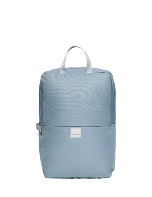 Sac à dos rectangulaire bleu clair avec poignée supérieure, sangle latérale et petite étiquette frontale avec le nom de la marque "Vaude".