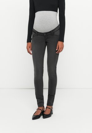 Graviditetsbukser i mørkegrå denim med et stretchy grått panel i midjen, kombinert med svart langermet topp og svarte hæler.