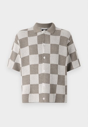 Chemise à manches courtes, à boutons, avec un motif en damier brun et blanc. Fabriquée en tissu tricoté texturé avec un col.